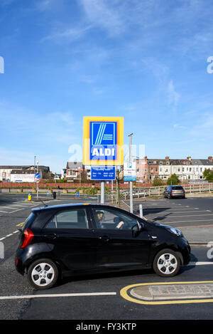 Il passaggio di un auto di aldi firmare all'entrata per il parcheggio di un grande supermercato Aldi in Blackpool, Lancashire, Regno Unito Foto Stock