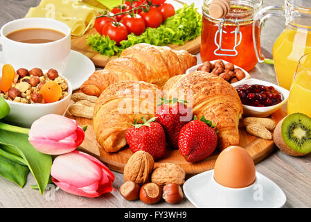 La prima colazione composta da cornetti, caffè, frutta, succo d'arancia, caffè e marmellata. Dieta bilanciata. Foto Stock