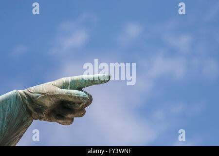 Mano puntare il dito indice contro il cielo blu. Statua di Karl XII re di Svezia in Kungstradgarden, Stoccolma. La Svezia. Foto Stock