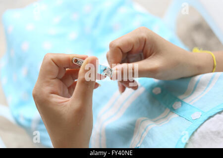 Donna incinta con il tagliaunghie per pulire il corpo a prepararsi per il parto. Foto Stock