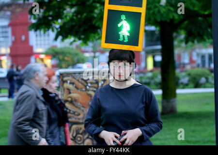 L'artista Kubra Khademi (Ghor, Afghanistan, 1989) ha girato le strade di Gijon semaforo mascherata per una performance dal titolo "Kubra e crosswalks III " con lo scopo di combattere il machismo. Sul suo capo che indossava una casella arancione, simulando un semaforo con due anse, compresi due bulbi, uno verde e uno rosso e sul loro due cartone nero con fori a forma di donna. Una donna con abito di criticare il machismo che sta dietro a un semaforo per utilizzando le figure pantaloni. Foto Stock