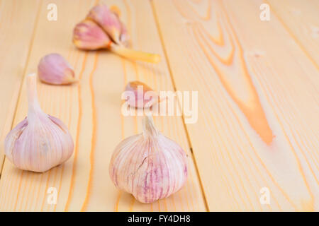 Testa di aglio isolata su uno sfondo di legno. Foto Stock