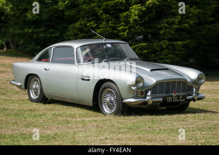 Immagine di panorama di un classico della Aston Martin DB4 auto in argento, isolato e parcheggiata su erba. Foto Stock