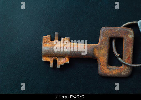 Vecchia chiave arrugginita su sfondo scuro Foto Stock