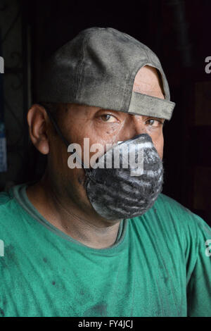 Lavoro duro uomo viso coperto con olio e maschera Foto Stock