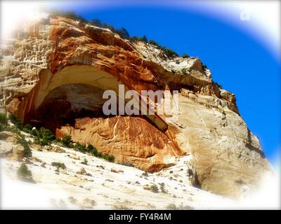 Caverna di montagna bright bianco su rosso arancio della roccia, cielo blu. Foto Stock