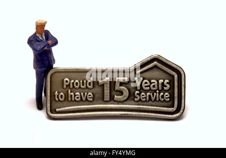 Una miniatura del business man in piedi accanto a un mulino Dunelm quindici anni badge servizio Foto Stock