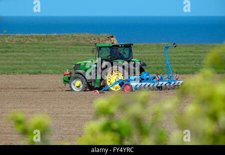 Il trattore e erpice a dischi sulla costiera di terra agricola, weybourne, North Norfolk, Inghilterra Foto Stock