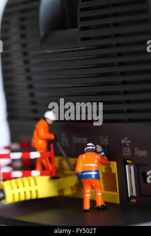 Miniatura lavoratori edili router cavo di collegamento Foto Stock