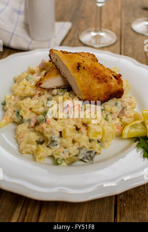 Tradizionale ceca Schnitzel con patate e insalata di verdure su tavola di legno Foto Stock