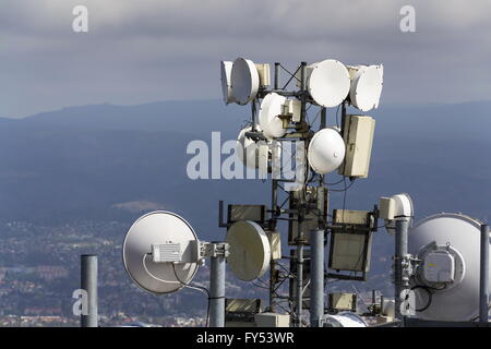 Mazzetto di trasmettitori e di antenne sulla torre di telecomunicazioni Foto Stock