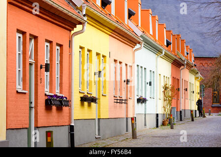 Trelleborg, Svezia - 12 Aprile 2016: fila di pastello case dipinte vicino alla chiesa in background. Una persona visibile a t Foto Stock