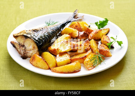 Patate arrosto e sgombro pesce sulla piastra Foto Stock