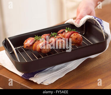 In suini coperte ( salsicce avvolto in pancetta ) su un vassoio di tostatura Foto Stock