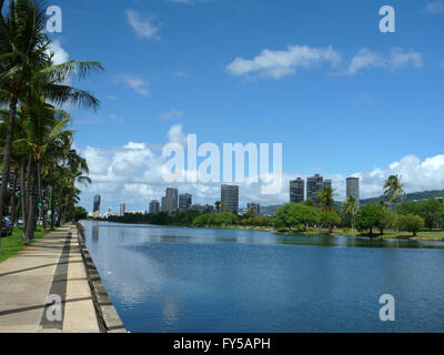 Ala Wai Canal, alberghi, condomini, Campi da Golf e gli alberi di cocco in una bella giornata di Waikiki di Oahu, Hawaii con montagne in dist Foto Stock