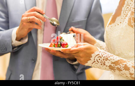 Sposa e lo sposo di mangiare la torta di nozze Foto Stock