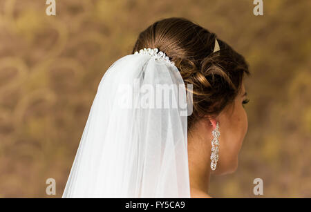 La stilista pinning di una sposa acconciatura e velo nuziale prima del matrimonio Foto Stock