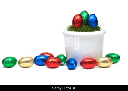 Vaso di fiori con erba e Pasqua egss avvolto nel foglio colorato, isolato Foto Stock