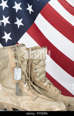 Vecchio stivali da combattimento e dog tag con bandiera americana in background Foto Stock