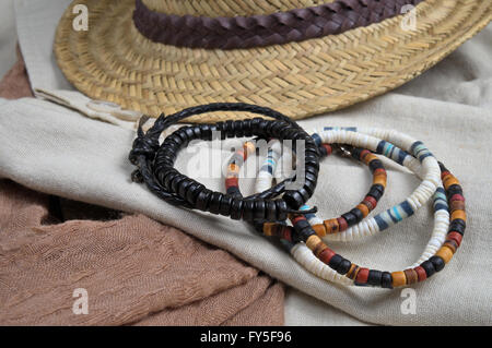 Cappello di paglia, sciarpa, biancheria classico cappotto e bracciali. Elegante vestito estivo tema Foto Stock