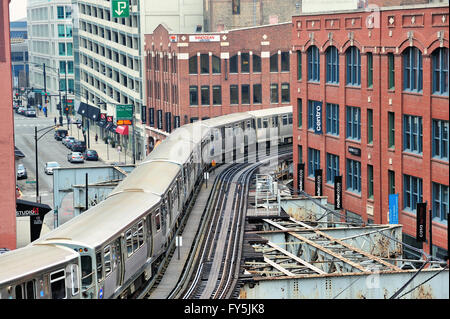 Un CTA linea marrone treno serpeggiando il suo modo attraverso una coppia di curve strette su tracce elevata in Chicago quartiere River North. Chicago, Illinois, Stati Uniti d'America. Foto Stock