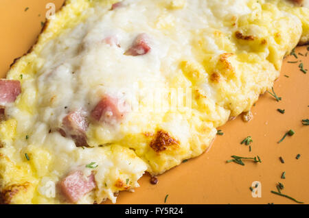 Appena tostato frittata con prosciutto e formaggio su una piastra. Tema colazione Foto Stock