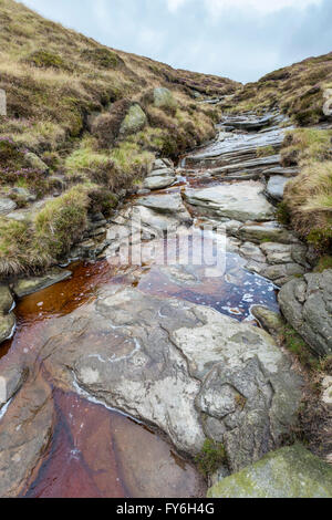 Moorland flusso che scorre in discesa su roccia vicino alla parte superiore della Crowden Clough, Kinder Scout, Derbyshire, England, Regno Unito Foto Stock