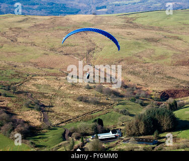 Parapendio volare sopra una valle gallese al di sopra di un hill farm Foto Stock