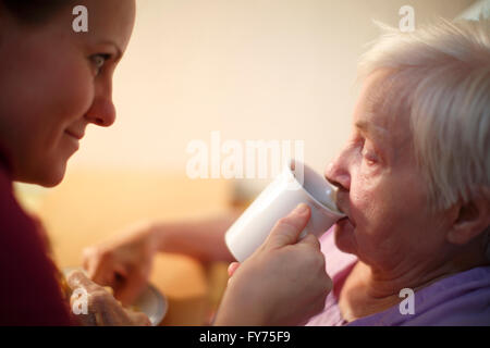 Donna, 85 anni, in una casa di cura, a colazione, supportato da un infermiere geriatrico, Kralovske Porici, Bohemia Repubblica Ceca Foto Stock