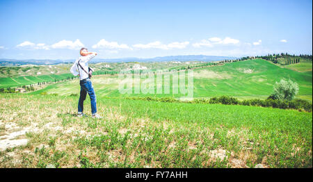 L'uomo guarda il paesaggio contemplare ammirare colline toscane verde Foto Stock