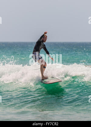 L'uomo corse la sua tavola da surf verso la riva Foto Stock