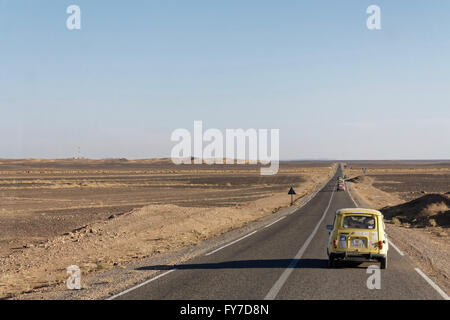 Una Volkswagen maggiolino sull'autostrada vicino Merzouga nel deserto del Marocco. Foto Stock