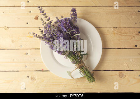 Impostazione posto sul tavolo in legno e decorate con bouquet di fiori di lavanda Foto Stock