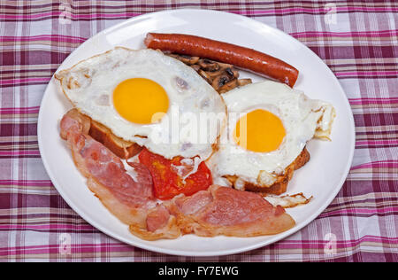 Colazione completa di pancetta e uova fritte su toast fritti con pomodoro e formaggio pancetta, salsicce e funghi Foto Stock