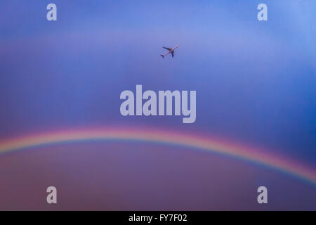 Regno Unito Meteo: un piano dal city airport è visto passando un colorato arcobaleno durante una serata breve acquazzone su Londra. Foto Stock