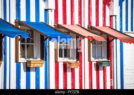 A strisce colorate case di pescatori in blu e rosso, Costa Nova, Aveiro, Portogallo Foto Stock