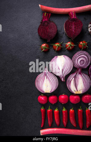 Red verdure tagliate a metà, piatto design laici su sfondo scuro, simmetrica. Foto Stock