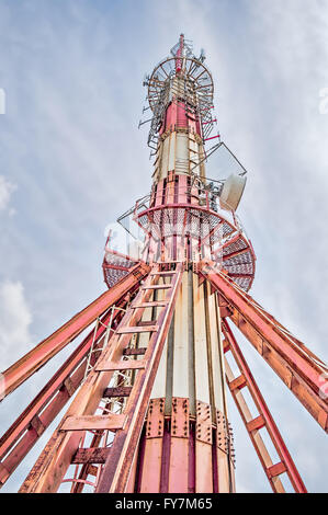 Rosso e bianco torre di telecomunicazioni sulla cima della montagna. Foto Stock