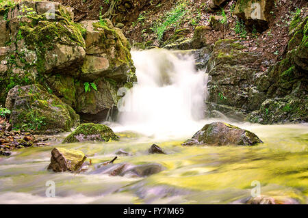 Una lunga esposizione foto di una piccola cascata in montagna. Foto Stock