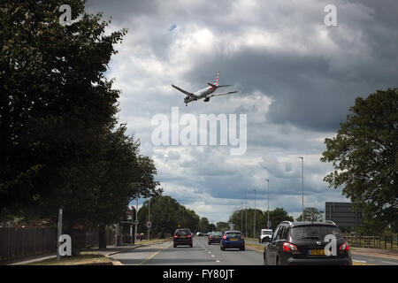 Un American Airlines sulla rotta di avvicinamento a Londra Heathrow, sopra la OCCUPATO A312 (Il Parkway) su strada Foto Stock