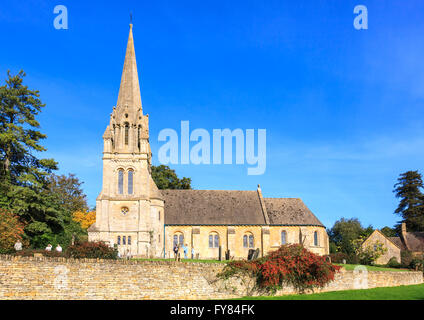 Santa Maria la chiesa parrocchiale con il suo tradizionale guglia, Batsford, Moreton-in-Marsh, Gloucestershire in una giornata di sole con cielo blu Foto Stock