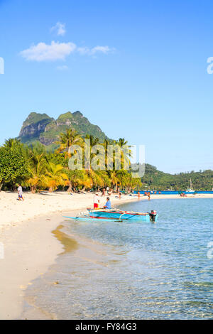 Spiaggia tropicale idilliaco con mentre la sabbia, palme e cielo blu in una giornata di sole, Bora Bora, Polinesia francese nell'Oceano Pacifico Foto Stock