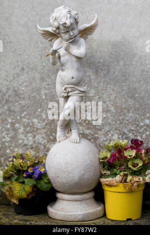 Statua di Pietra di un cherubino giocando un flauto Foto Stock