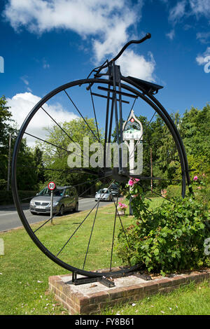 Regno Unito, Kent, Sissinghurst, gigante Penny Farthing scultura di metallo e segno di villaggio Foto Stock