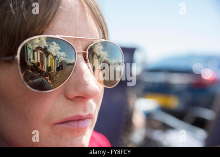 Cabine sulla spiaggia, nella riflessione dei giovani womans occhiali da sole Foto Stock