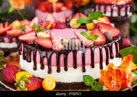 Delizioso a due veli Strawberry Cheesecake (torta decorata con cioccolato e frutti di bosco freschi Foto Stock