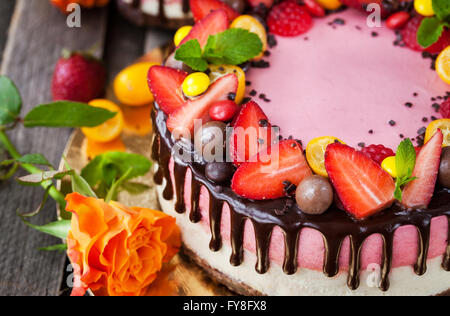 Delizioso a due veli Strawberry Cheesecake (torta decorata con cioccolato e frutti di bosco freschi Foto Stock