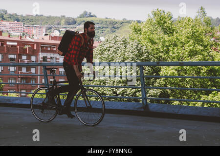 Spagna, Bilbao, uomo di equitazione ciclo racing su un ponte Foto Stock