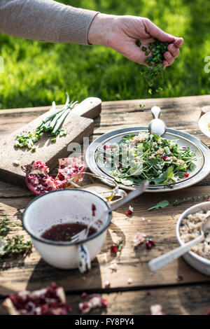 La preparazione di insalata verde con melograno, manna groppa e cipollina, melograno medicazione Foto Stock