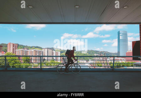 Spagna, Bilbao, uomo di equitazione ciclo racing su un ponte Foto Stock